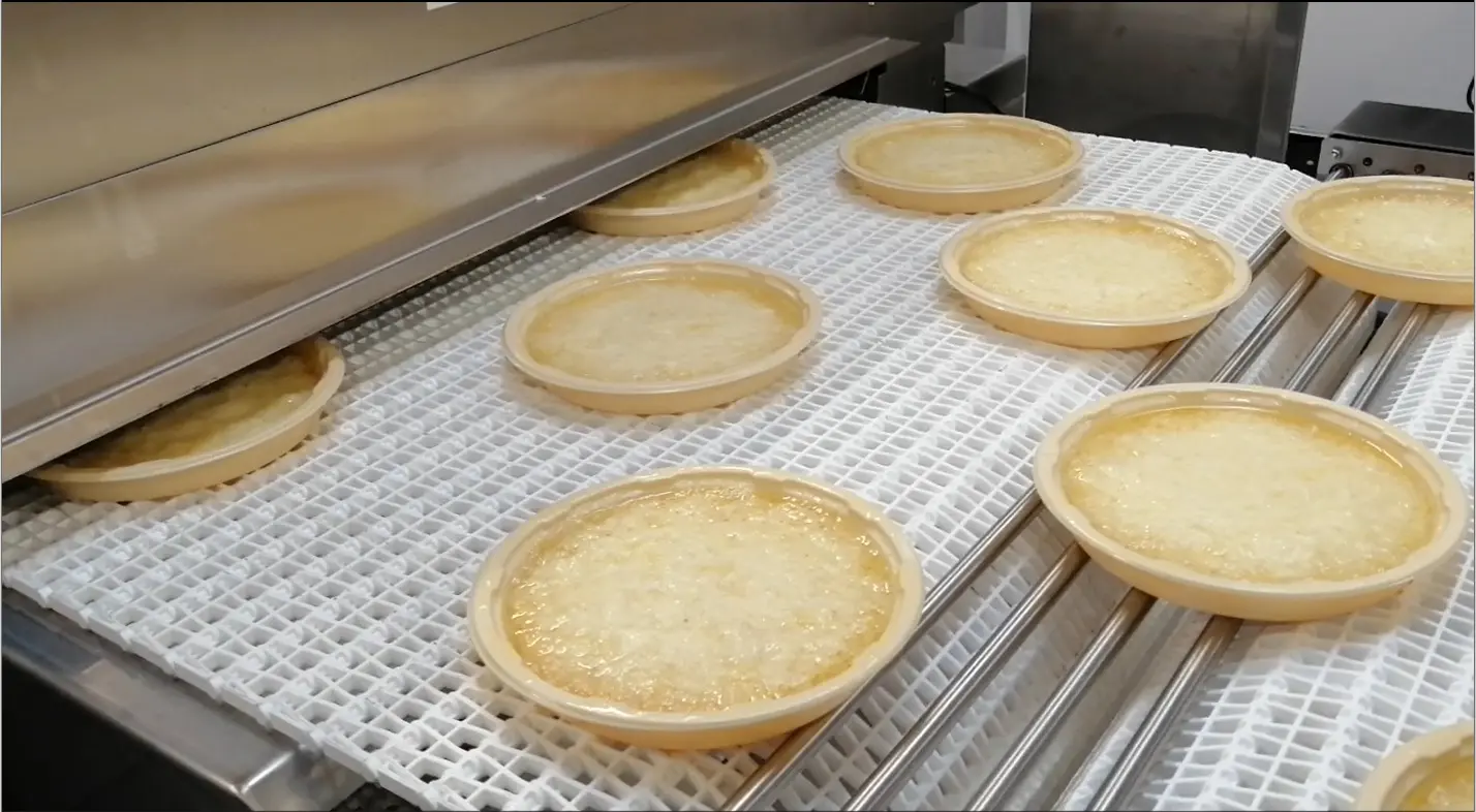 Open-packaged meals on the tunnel conveyor belt